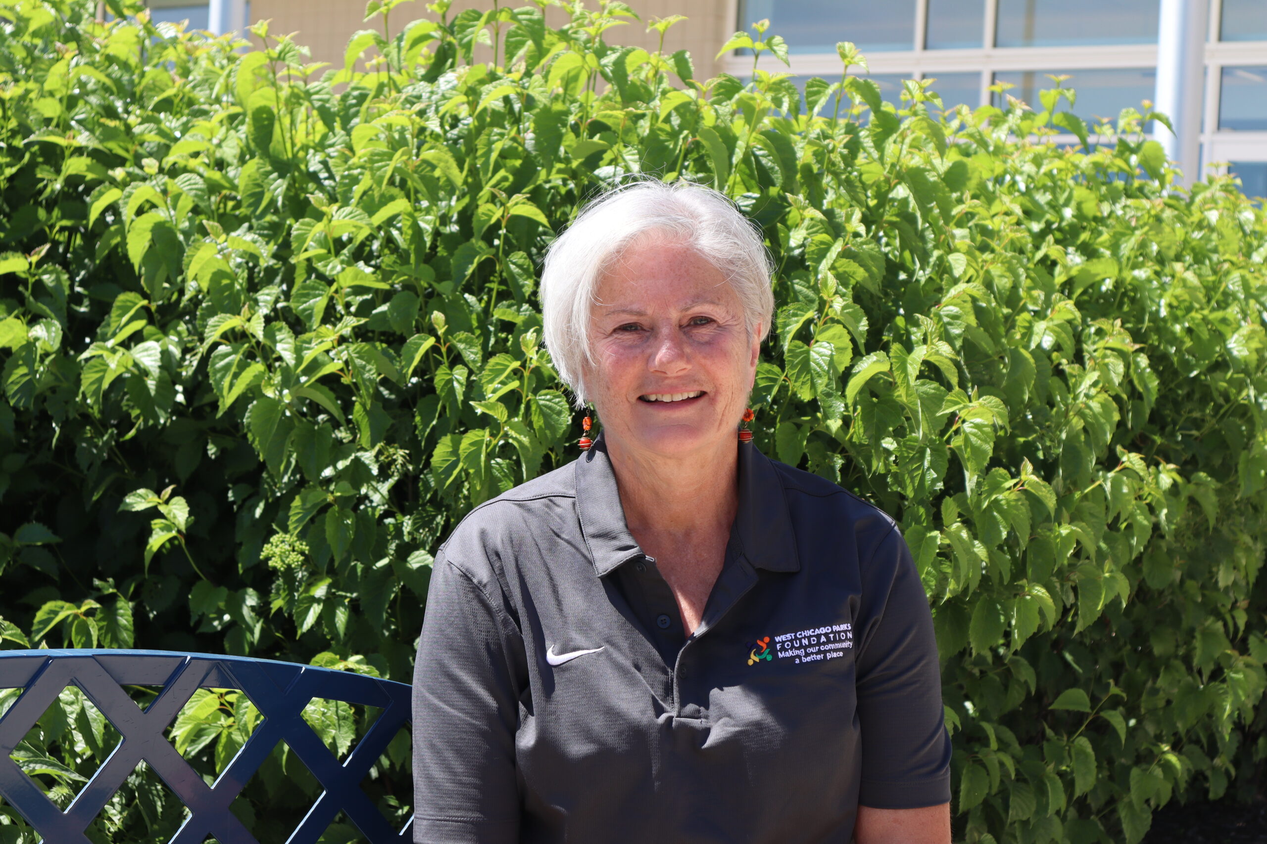 A headshot of Shawn Preuss. She is wearing a Foundation polo shirt and is seated outside smiling.