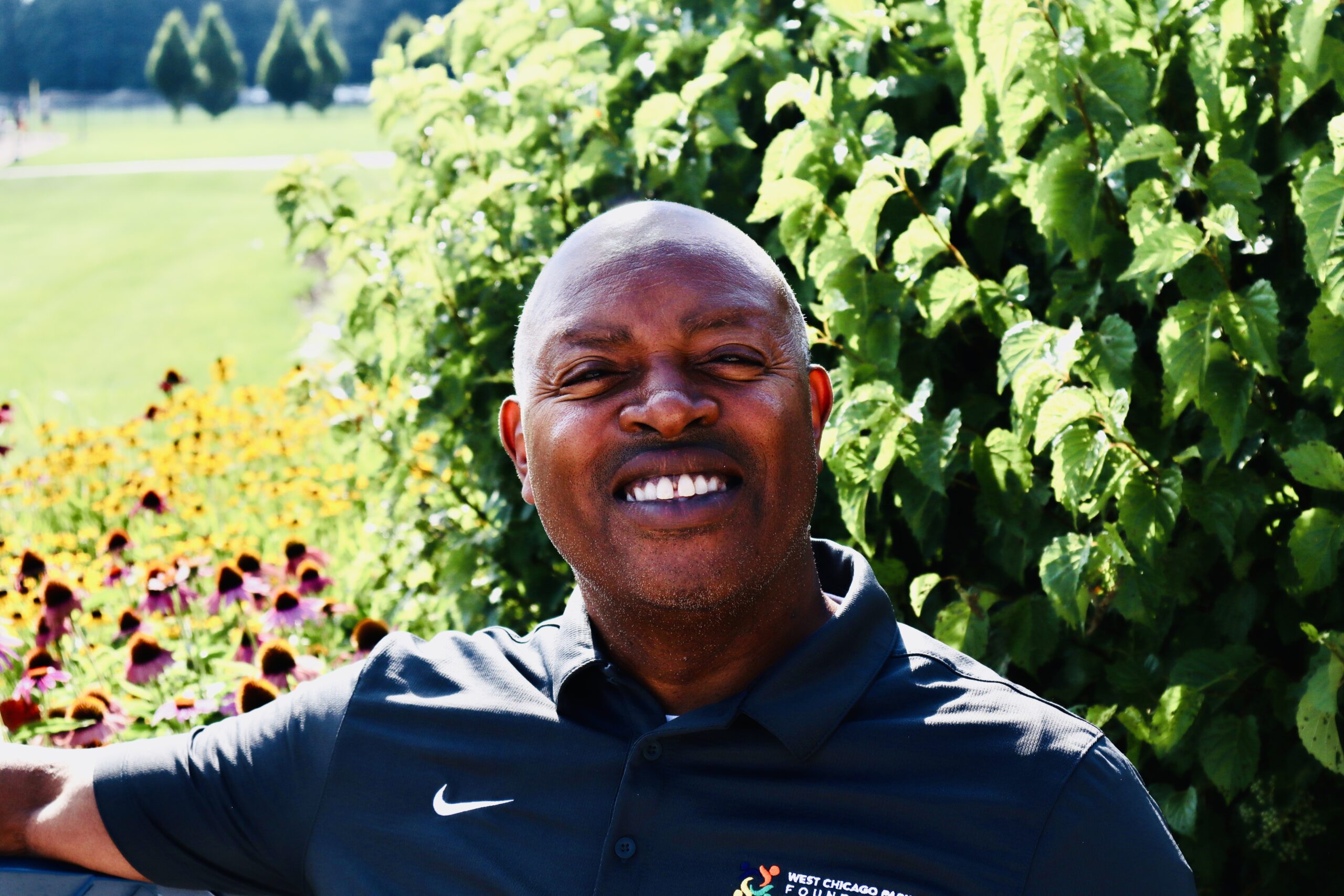 Headshot of Board president, Acie Boyd. He is smiling outside on a sunny day. 